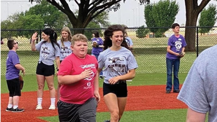 Dream League participant runs the bases with support from volunteers during a baseball game at the Dream League Field in Ackley Park, Elk City, Oklahoma.