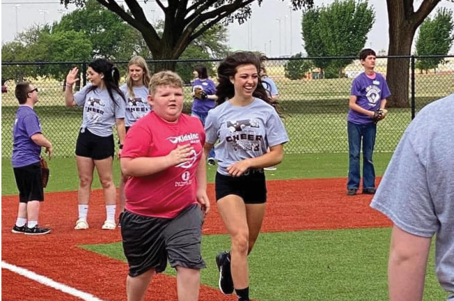 Dream League participant runs the bases with support from volunteers during a baseball game at the Dream League Field in Ackley Park, Elk City, Oklahoma.